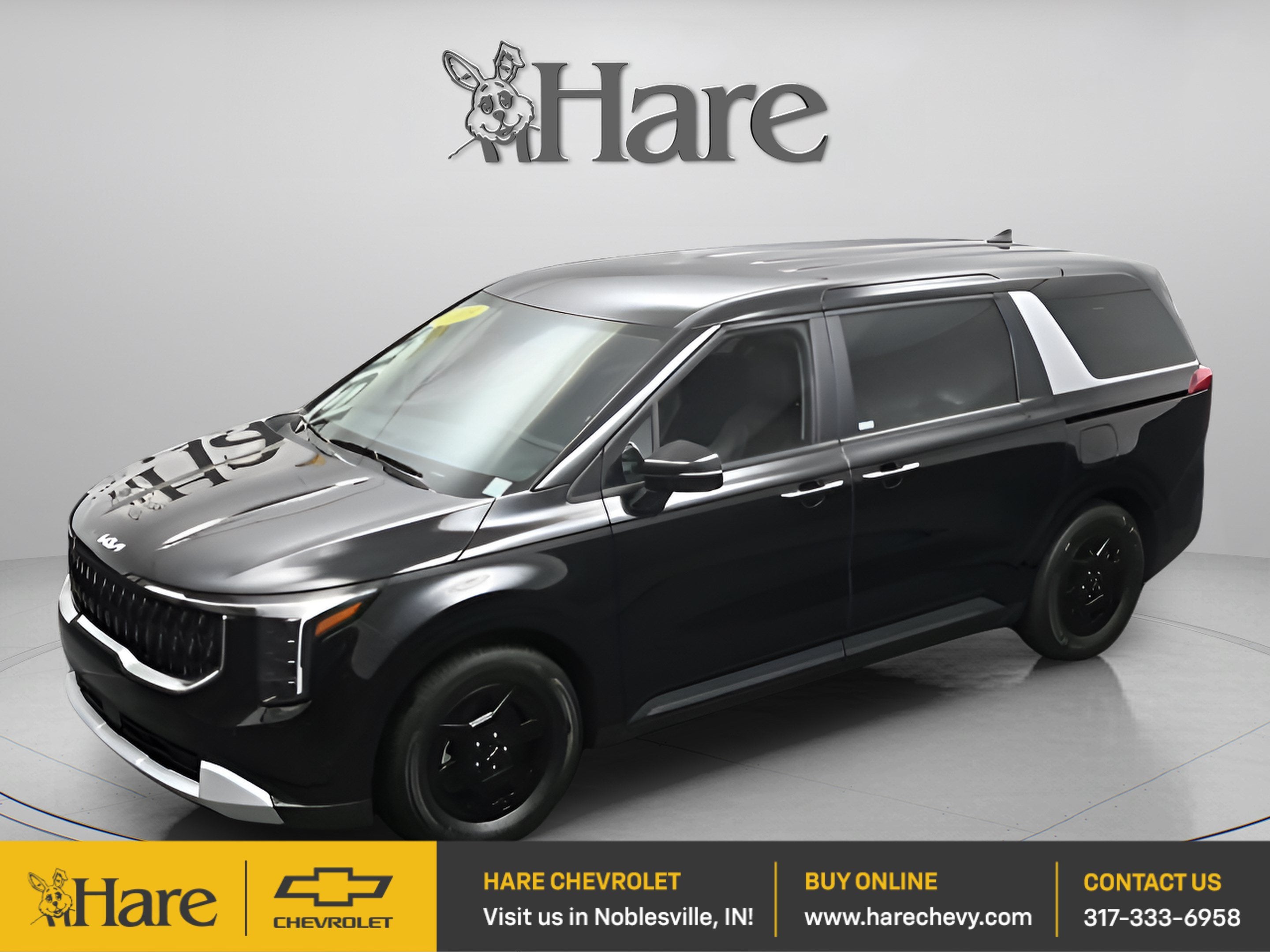 2025 Kia Carnival LXS in Aurora Black Pearl — front three-quarter view